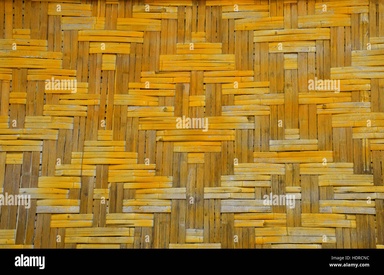Wicker braided bamboo yellow and brown painted wall texture pattern Stock Photo