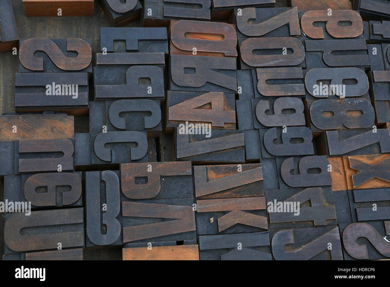 Old dark wooden vintage antique offset typography letterpress printing blocks grunge dirty with paint, mixed alphabet, close up, high angle view Stock Photo