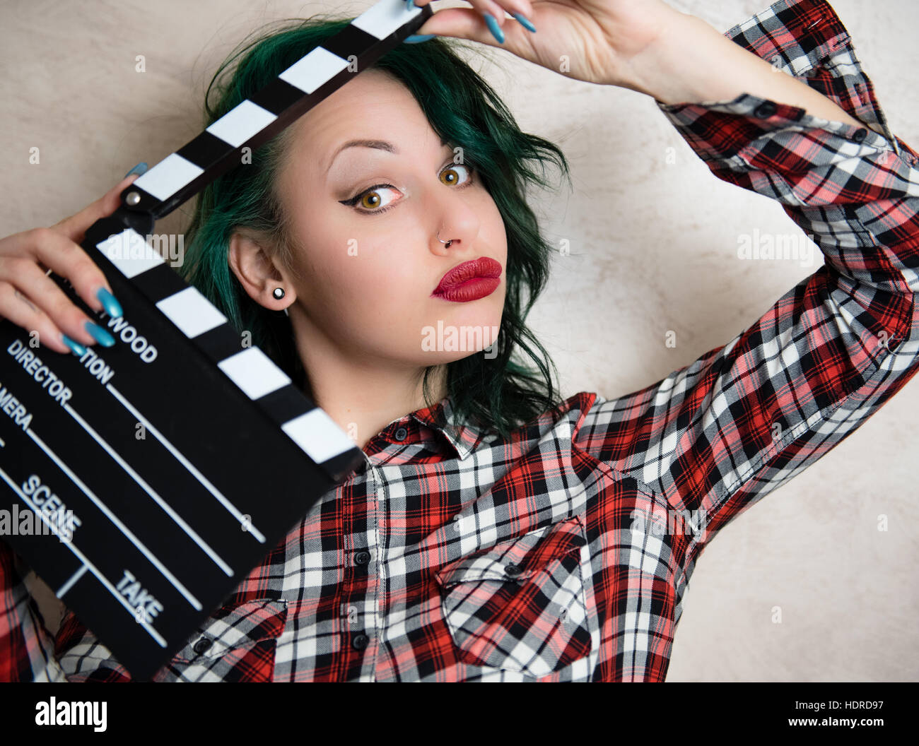 Young alternative girl grimace face and posing with movie clapper board for actress audition Stock Photo