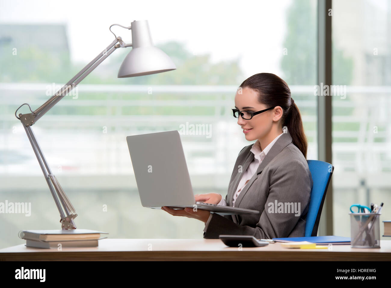 Businesswoman working at her desk Stock Photo - Alamy