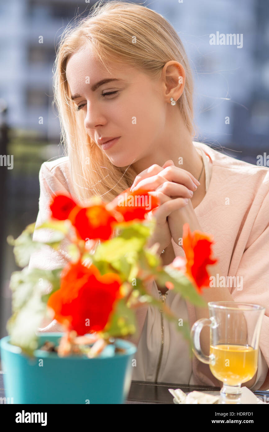 sad blond woman with cup of tea in street cafe Stock Photo - Alamy