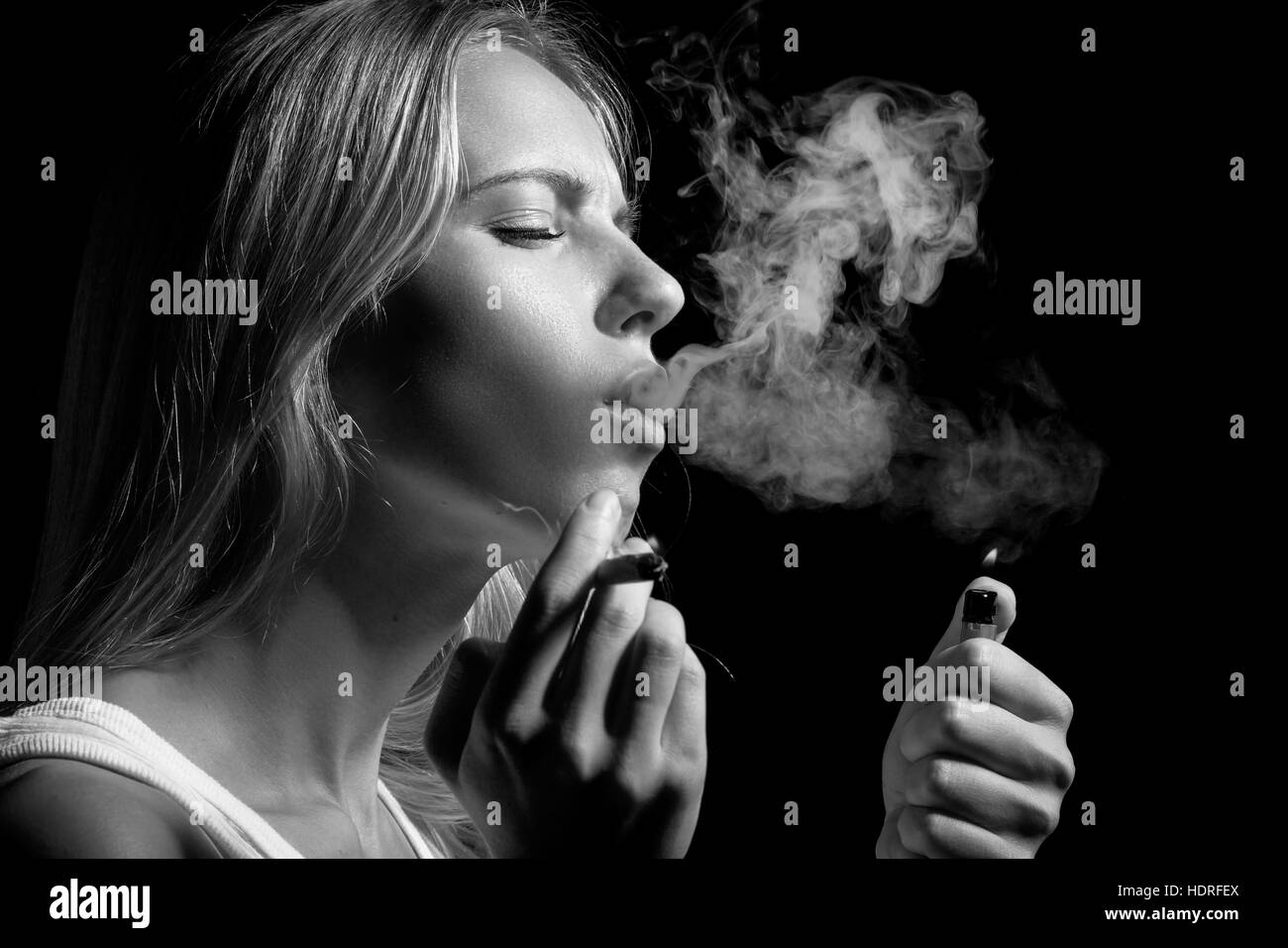 blond young woman smoking on black background, monochrome Stock Photo ...
