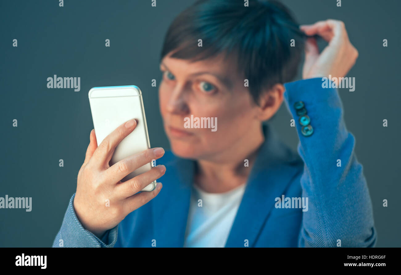 Businesswoman taking selfie portrait with mobile phone before important business meeting in office Stock Photo