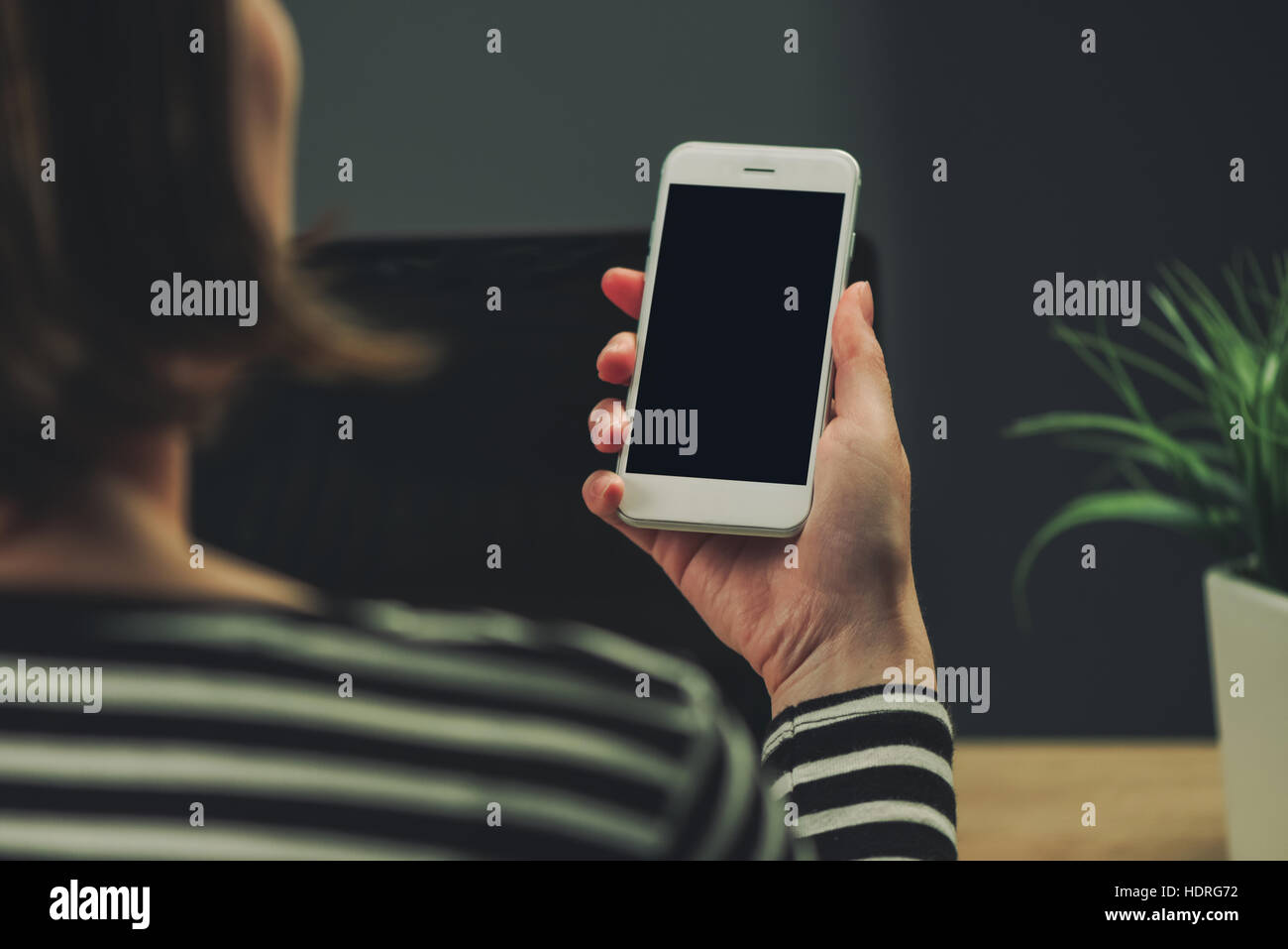 Businesswoman looking at smartphone blank screen as copy space in business office interior Stock Photo