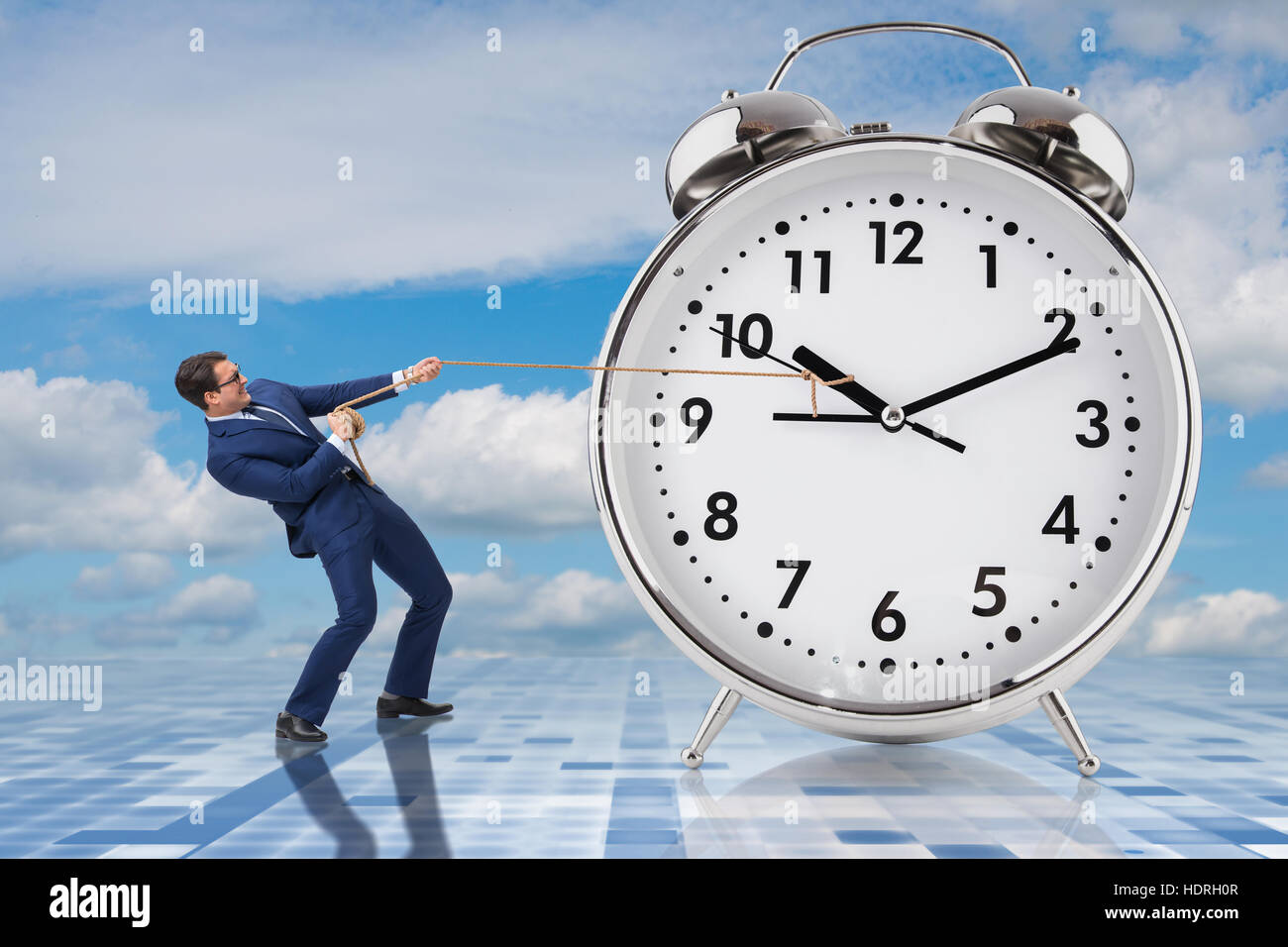 Businessman pulling clock in time management concept Stock Photo Alamy