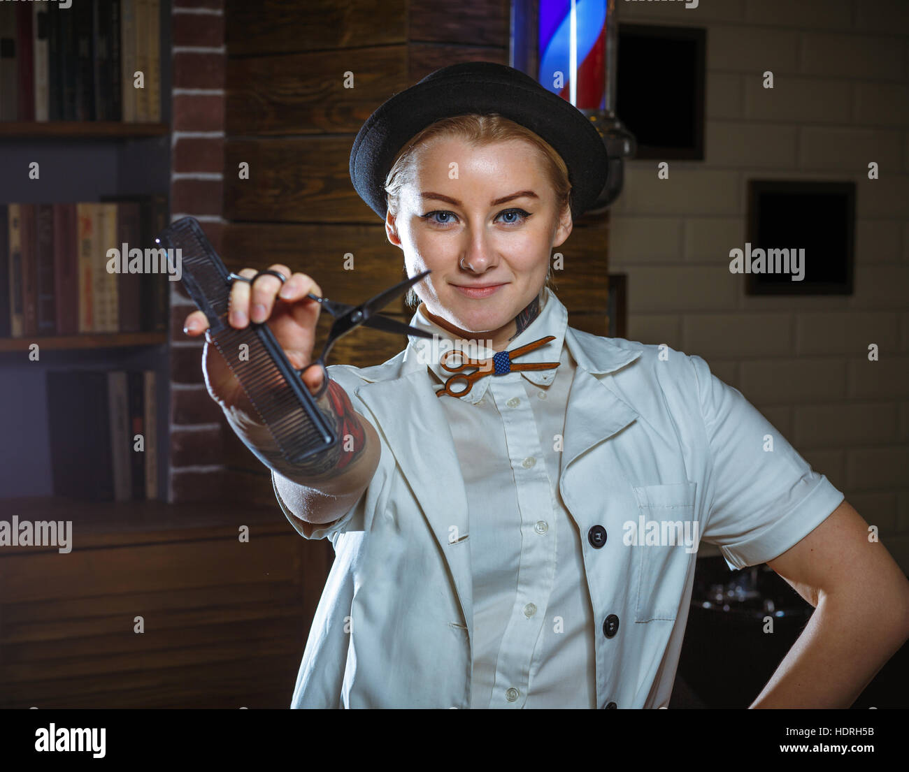 Portrait of fashion woman barber hairstylist with scissors in hand in