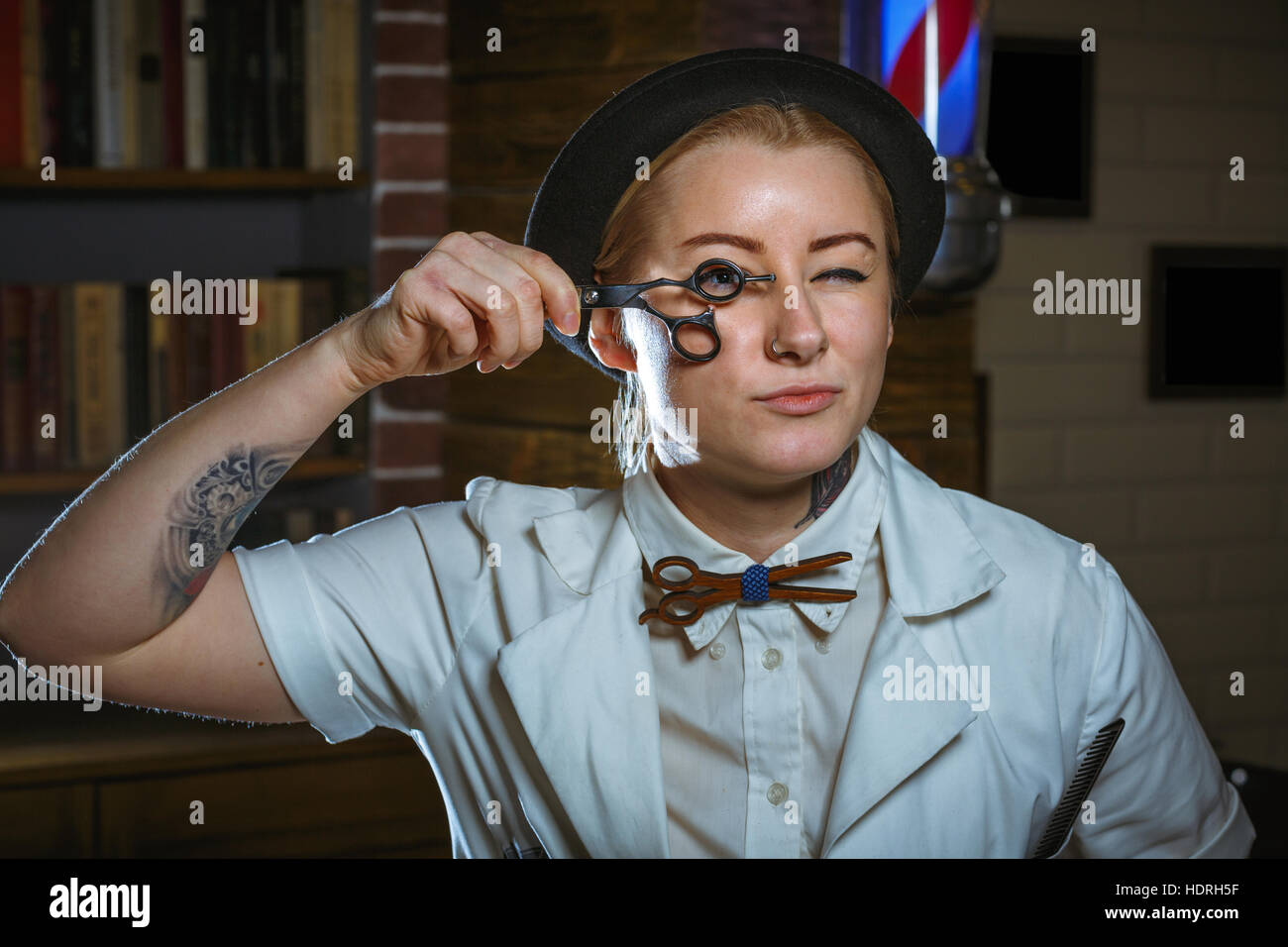 Portrait of fashion woman barber hairstylist with scissors in hand in