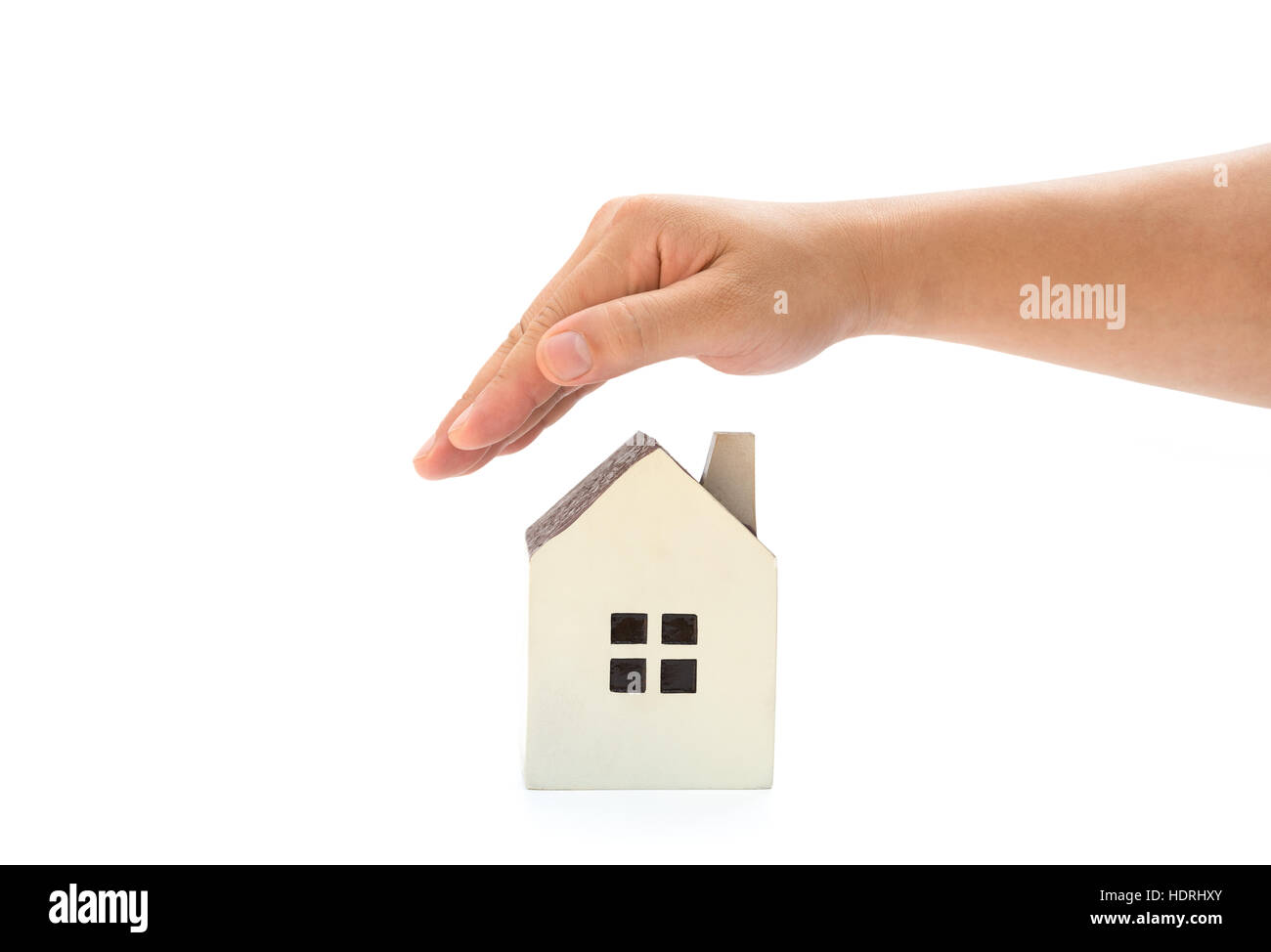 right hand covering a small family house with clipping path, home insurance concept or representing home ownership Stock Photo
