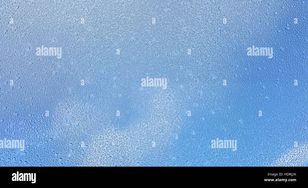 Water drops on glass with blurred blue sky background Stock Photo - Alamy