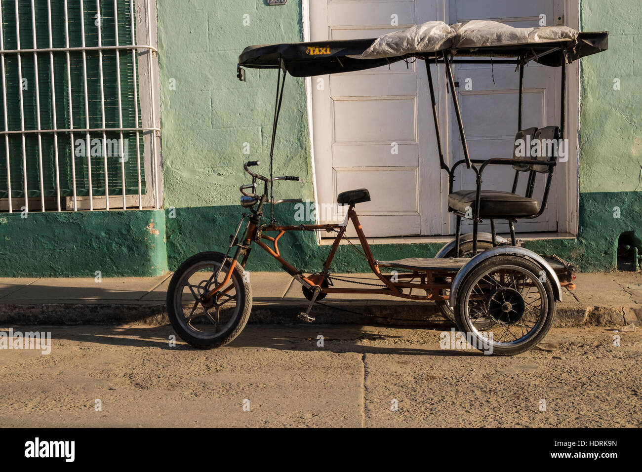 Tricycle taxi parked outside house, Trinidad, Cuba Stock Photo