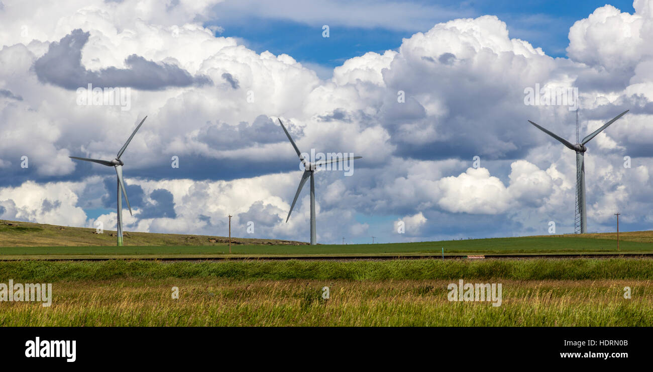 Wind turbines on a field with train tracks, with cloud; Pincher Creek, Alberta, Canada Stock Photo