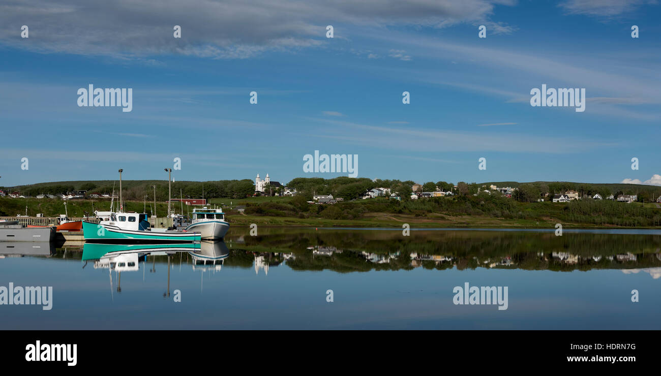 Mirror image of fishing boats and the shoreline in Inverness Harbour, Cape Breton Island; Nova Scotia, Canada Stock Photo