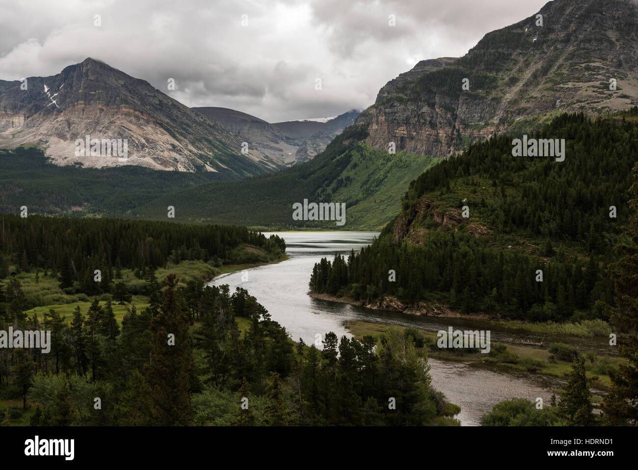 Tranquil river flowing through rugged mountains in Glacier National Park; Browning, Montana, United States of America Stock Photo