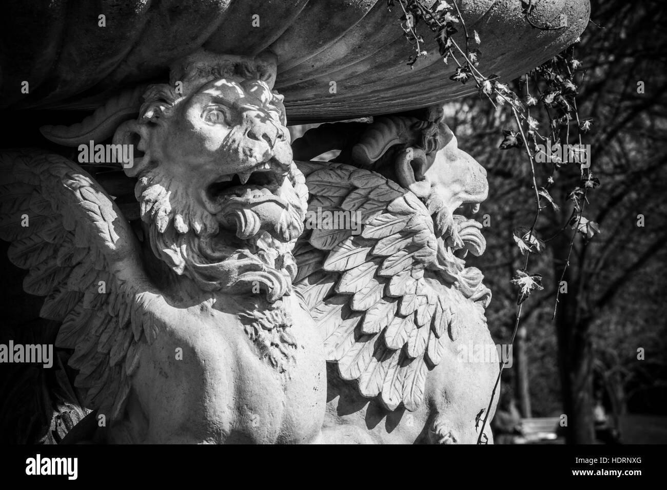 Winged lions hold up a beautiful planter of vines and flowers in The Avenue Gardens, Regent's Park; London, England Stock Photo