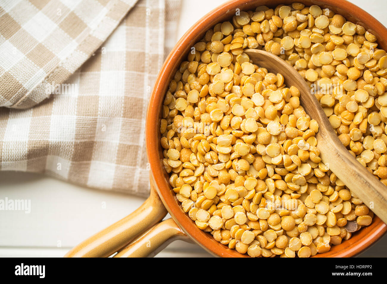 Yellow split peas in bowl on wooden table. Top view. Stock Photo