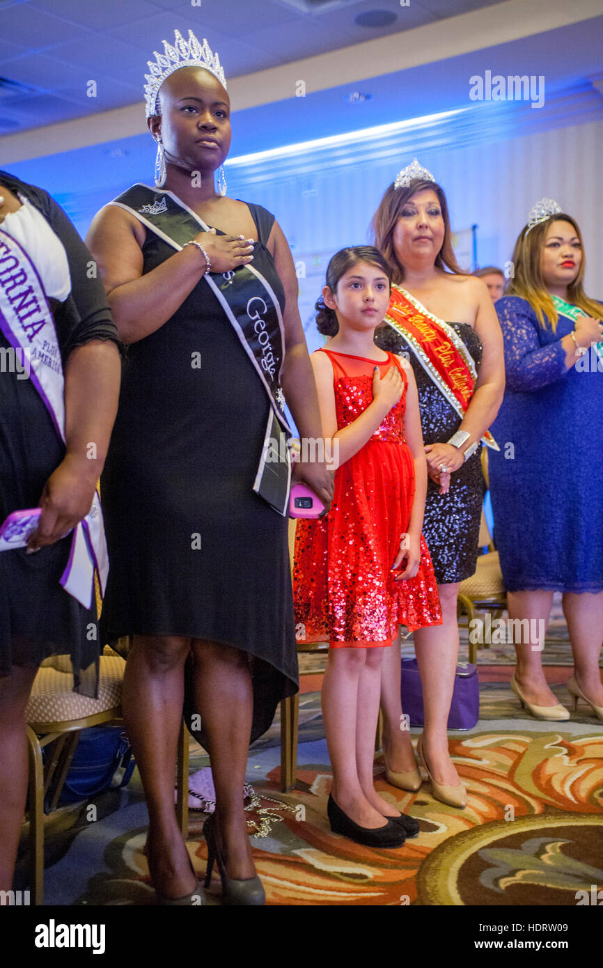 African American, Hispanic and Caucasian plus size women recite the Pledge of Allegiance at the California Plus American Pageant in Anaheim, CA. The event promotes female body acceptance. Stock Photo