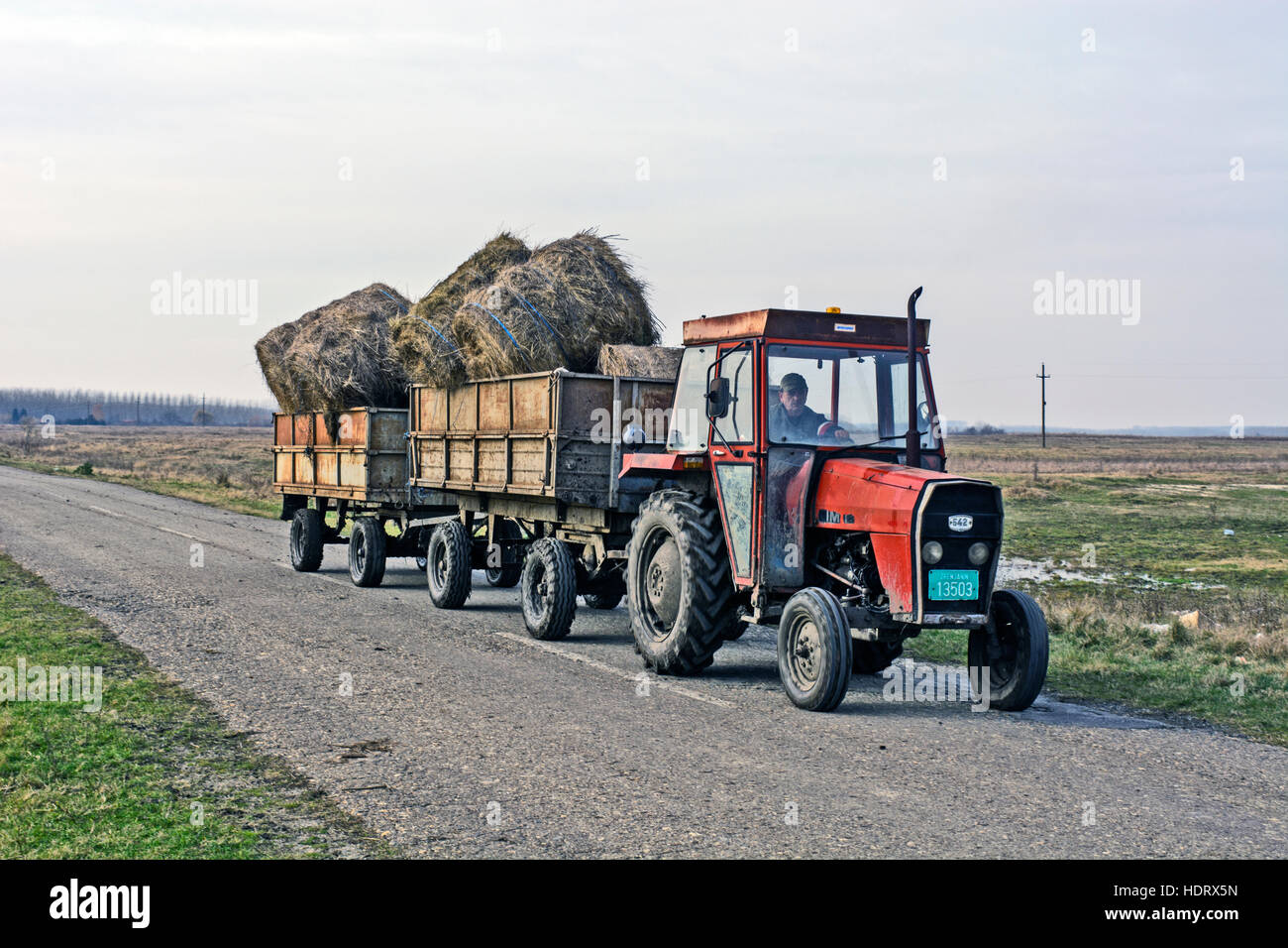 Zrenjanin, Serbia, November 16, 2016. Tractor with two trailers transporting hay. Stock Photo