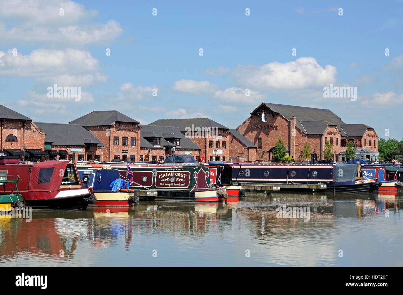 Narrowboats on their moorings in the canal basin with shops, bars and