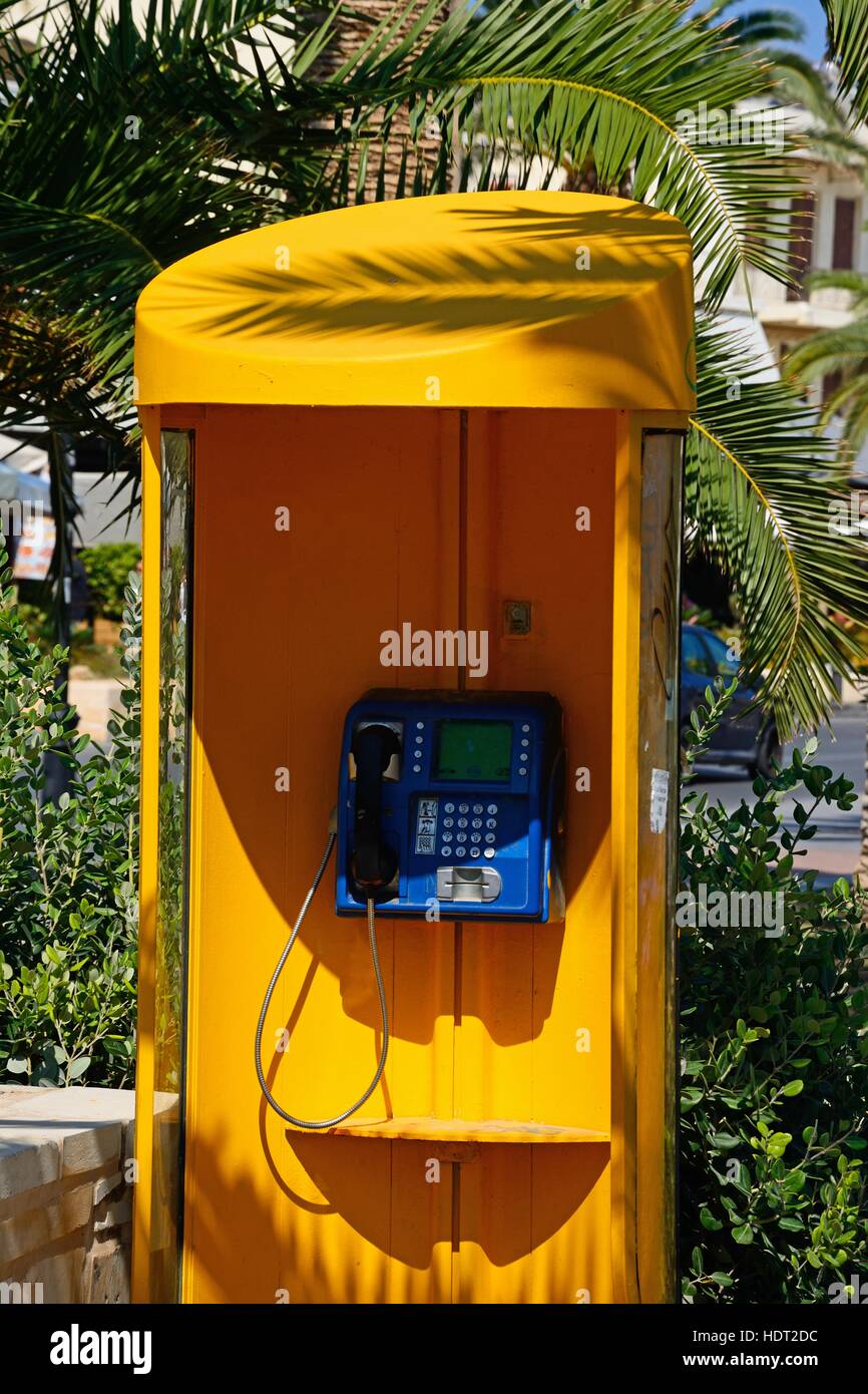 Yellow telephone kiosk along the promenade, Rethymno, Crete, Greece, Europe. Stock Photo