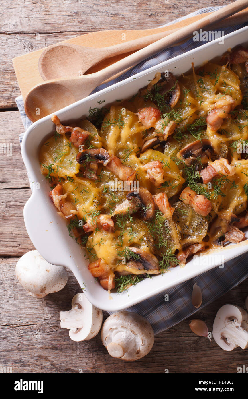 Baked potatoes with bacon and mushrooms close up. vertical top view
