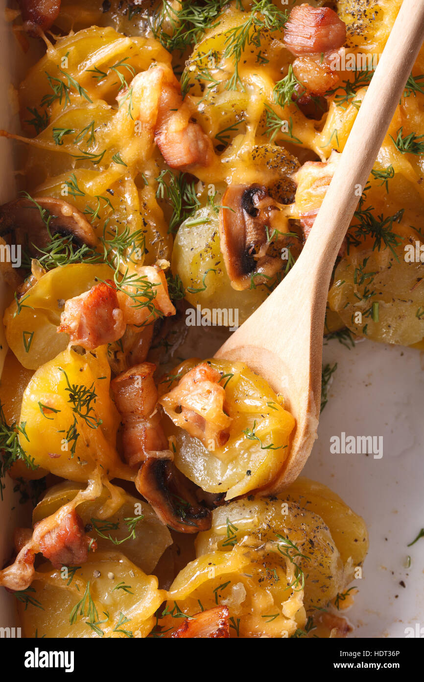 baked potato with bacon, mushrooms and cheese closeup with a wooden