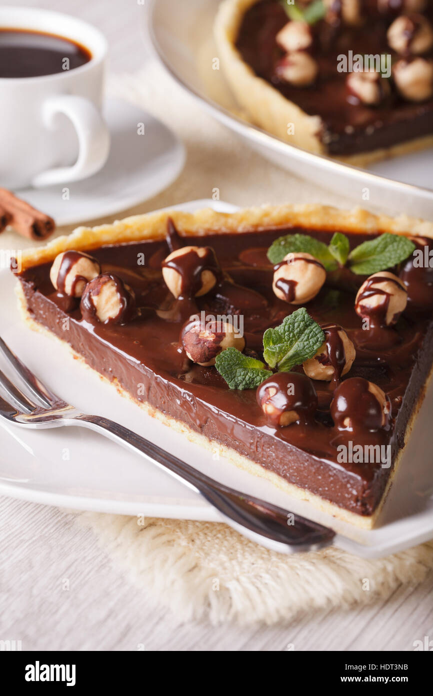 Chocolate tart with hazelnut and coffee on the table close-up. Vertical Stock Photo