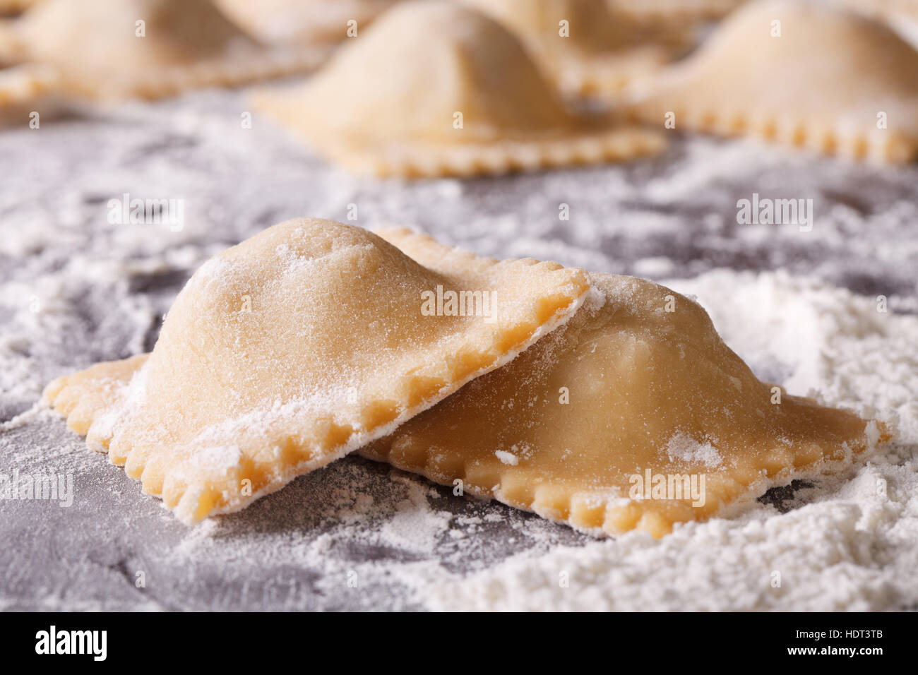 Italian uncooked ravioli on a floured table macro. horizontal Stock Photo