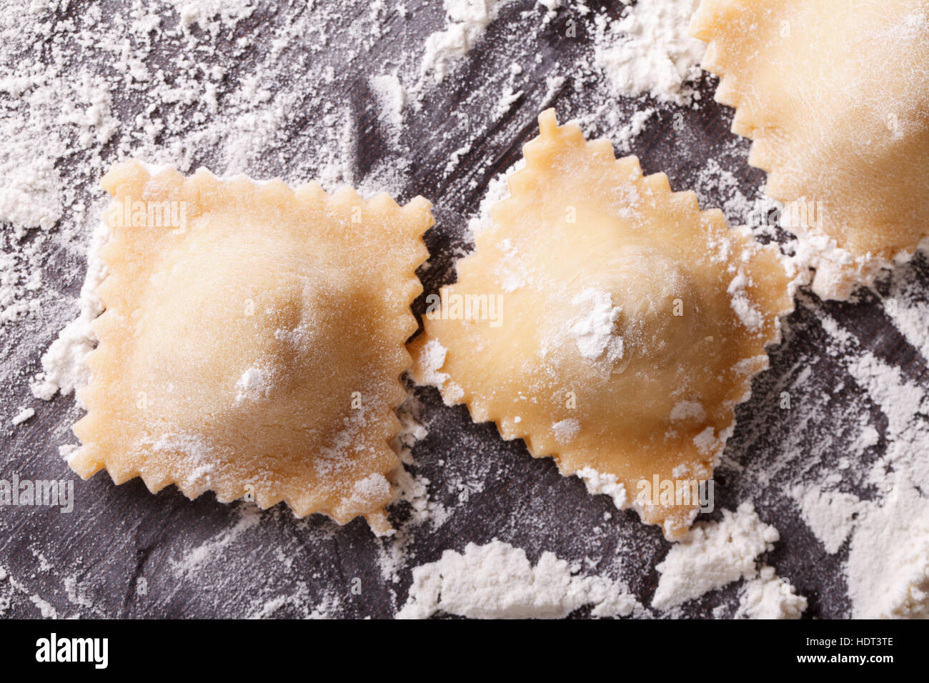 Italian raw ravioli on a floured table macro. Horizontal top view Stock Photo