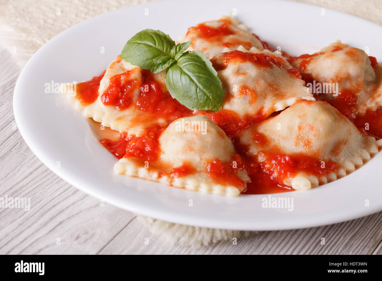 Ravioli stuffed with meat in tomato sauce on a plate close-up. horizontal Stock Photo