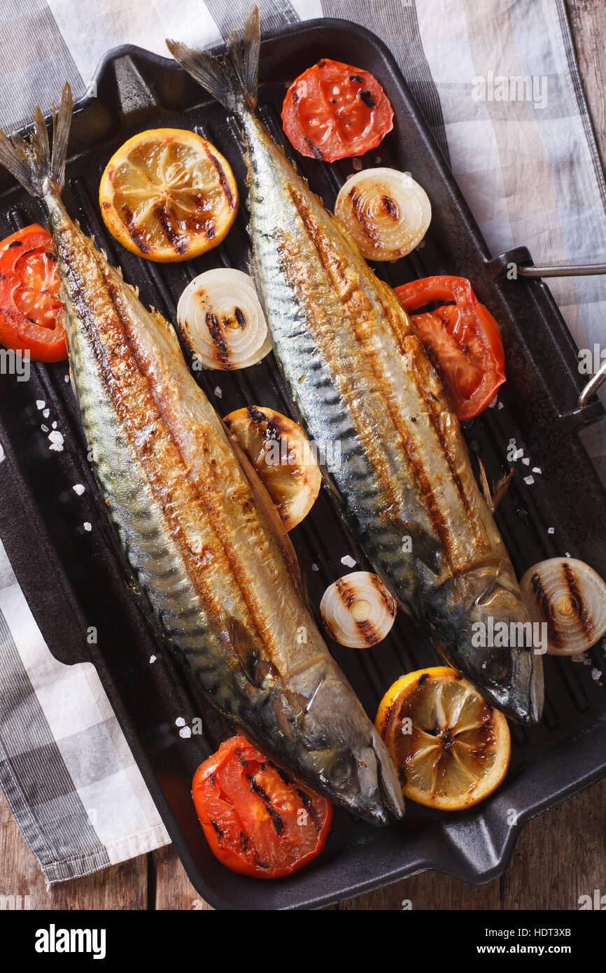Grilled mackerel fish and vegetables in a pan grill closeup. vertical