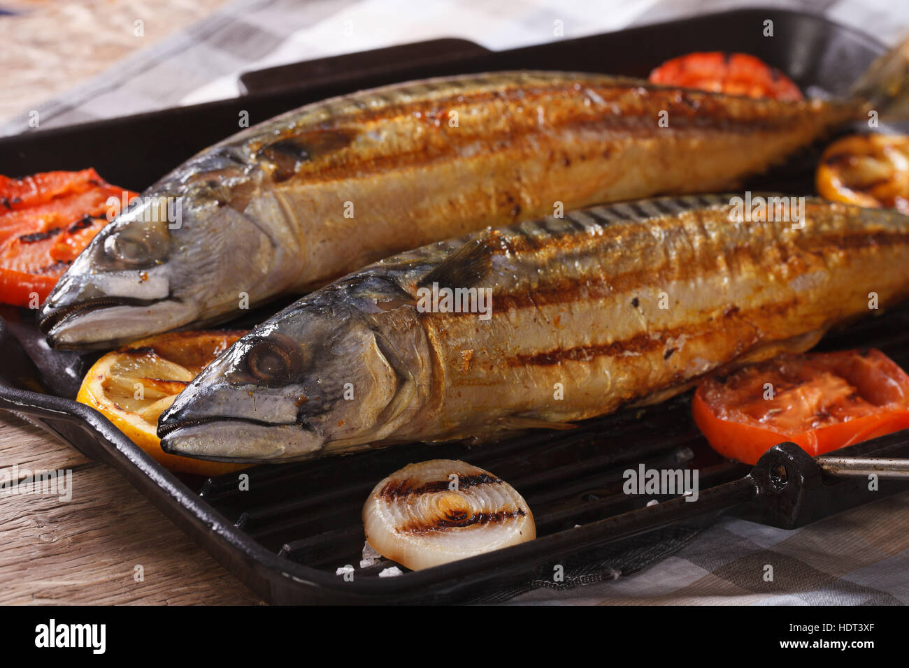 sea fish grilled mackerel and vegetables on the grill pan closeup. horizontal Stock Photo
