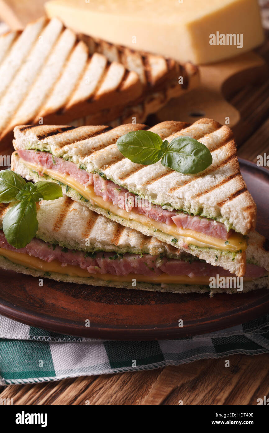 Hot toast with ham, cheese and basil closeup on a plate. vertical