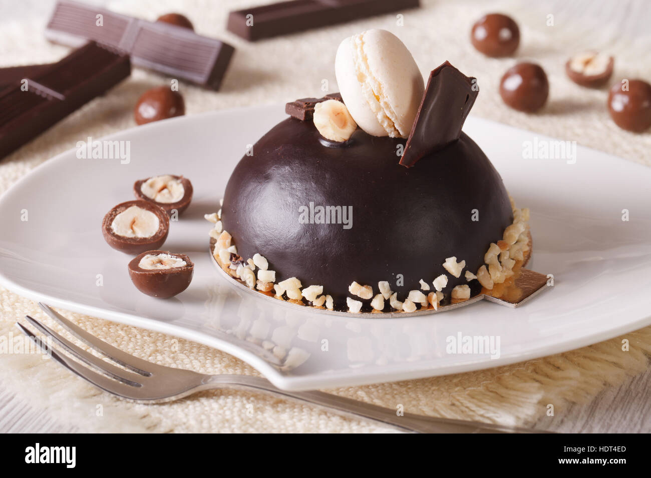 chocolate cake with hazelnuts, decorated macaroon on a plate. horizontal Stock Photo