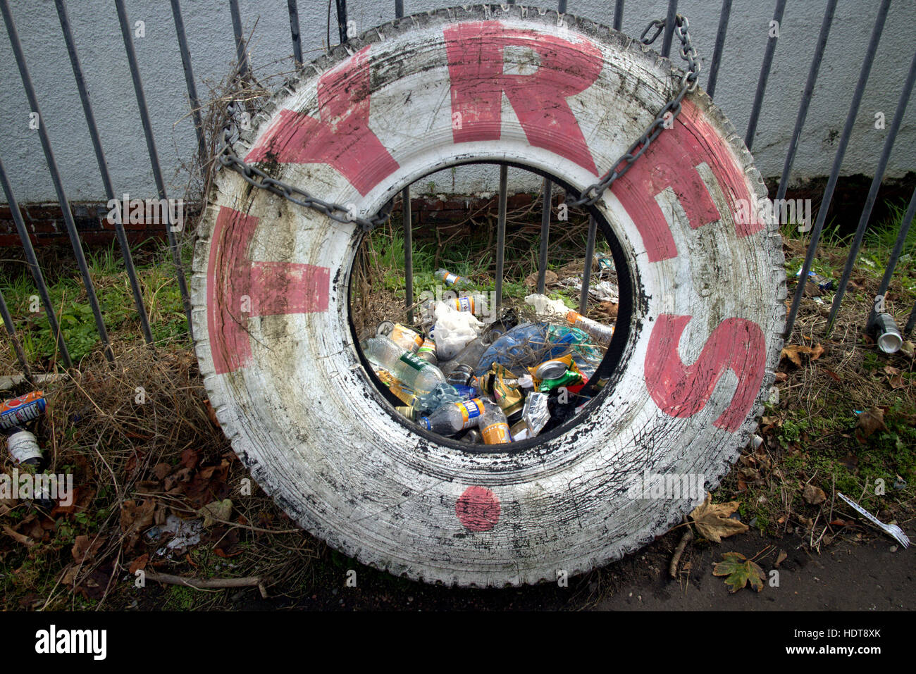 tyres sign painted red on white  filled with litter rubbish Stock Photo