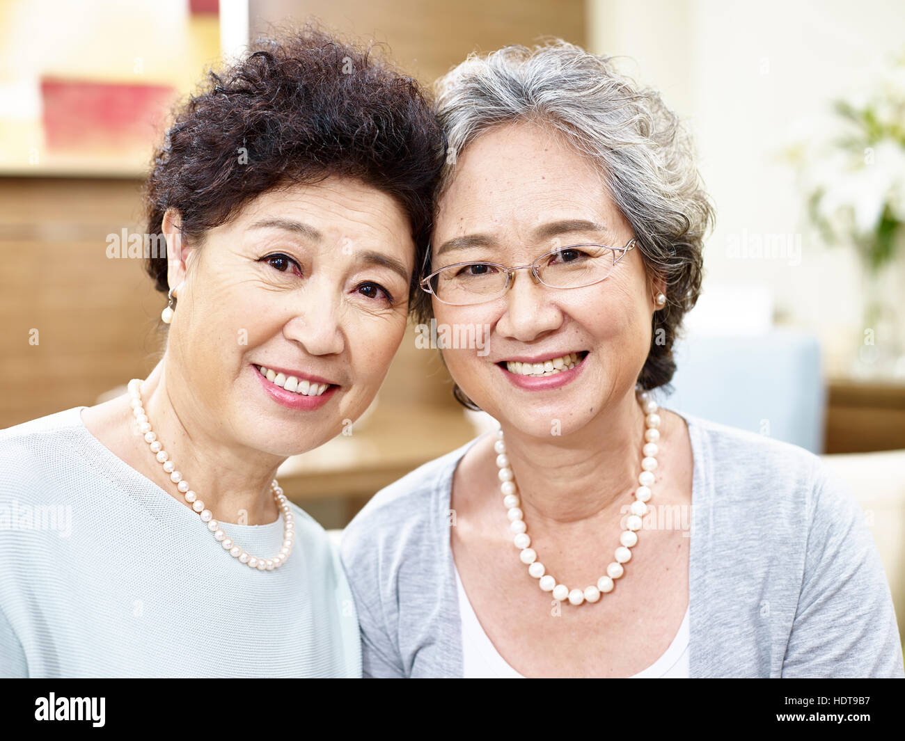 portrait of two senior asian women looking at camera smiling Stock Photo
