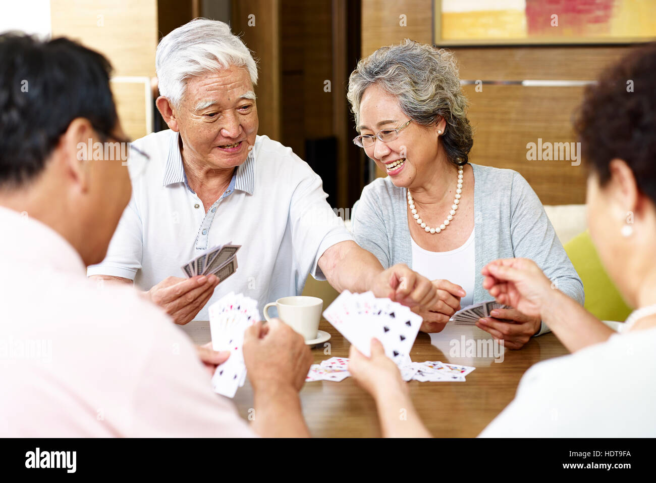 tow senior asian couples playing cards together Stock Photo