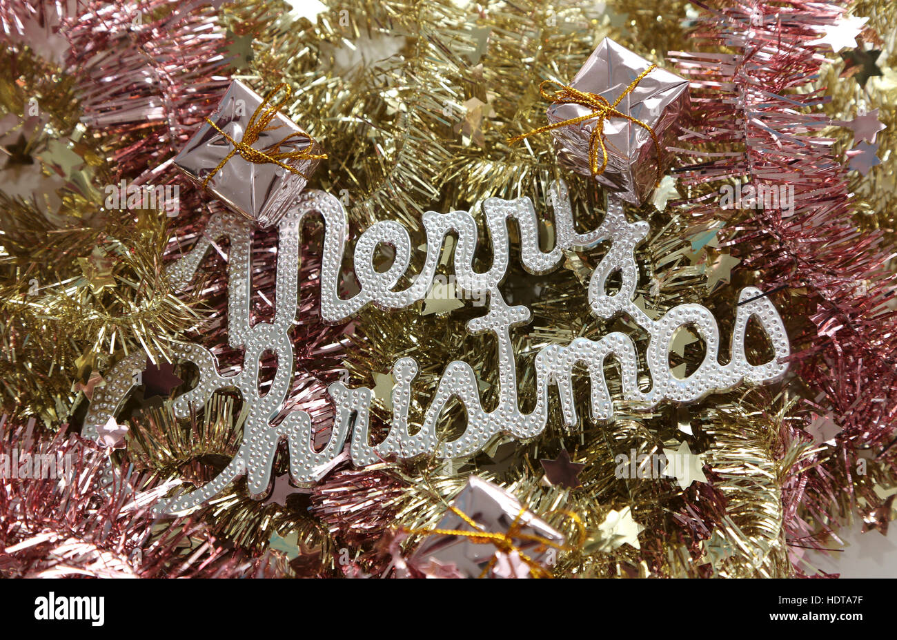 Merry Christmas on pink and golden tinsel Stock Photo