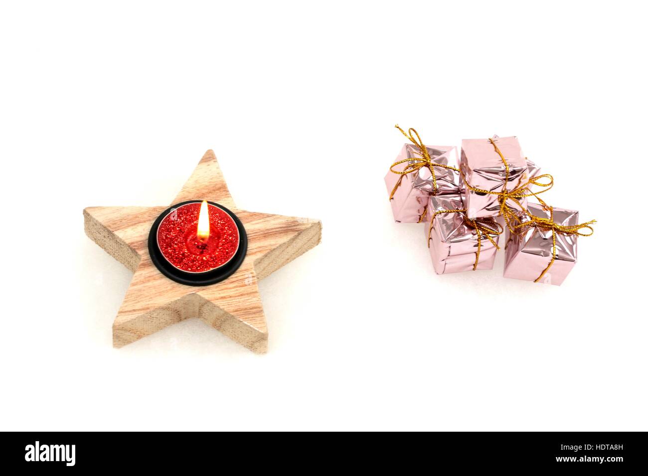 Little Christmas gifts next to a candle Stock Photo Alamy