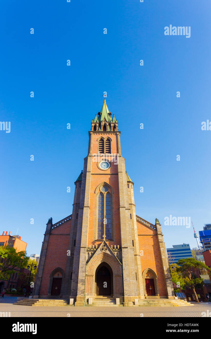 Centered front brick facade of Myeongdong Cathedral with clear blue sky on sunny spring day in Seoul, South Korea Stock Photo