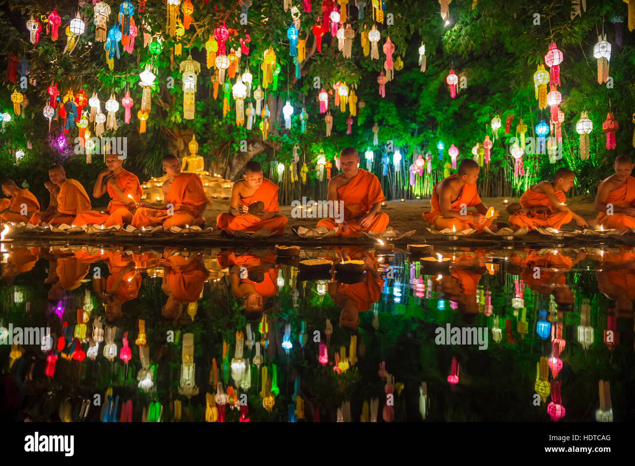 CHIANG MAI, THAILAND - NOVEMBER 06, 2014: Young Buddhist monks sit meditating at a festival of lights loi krathong ceremony. Stock Photo