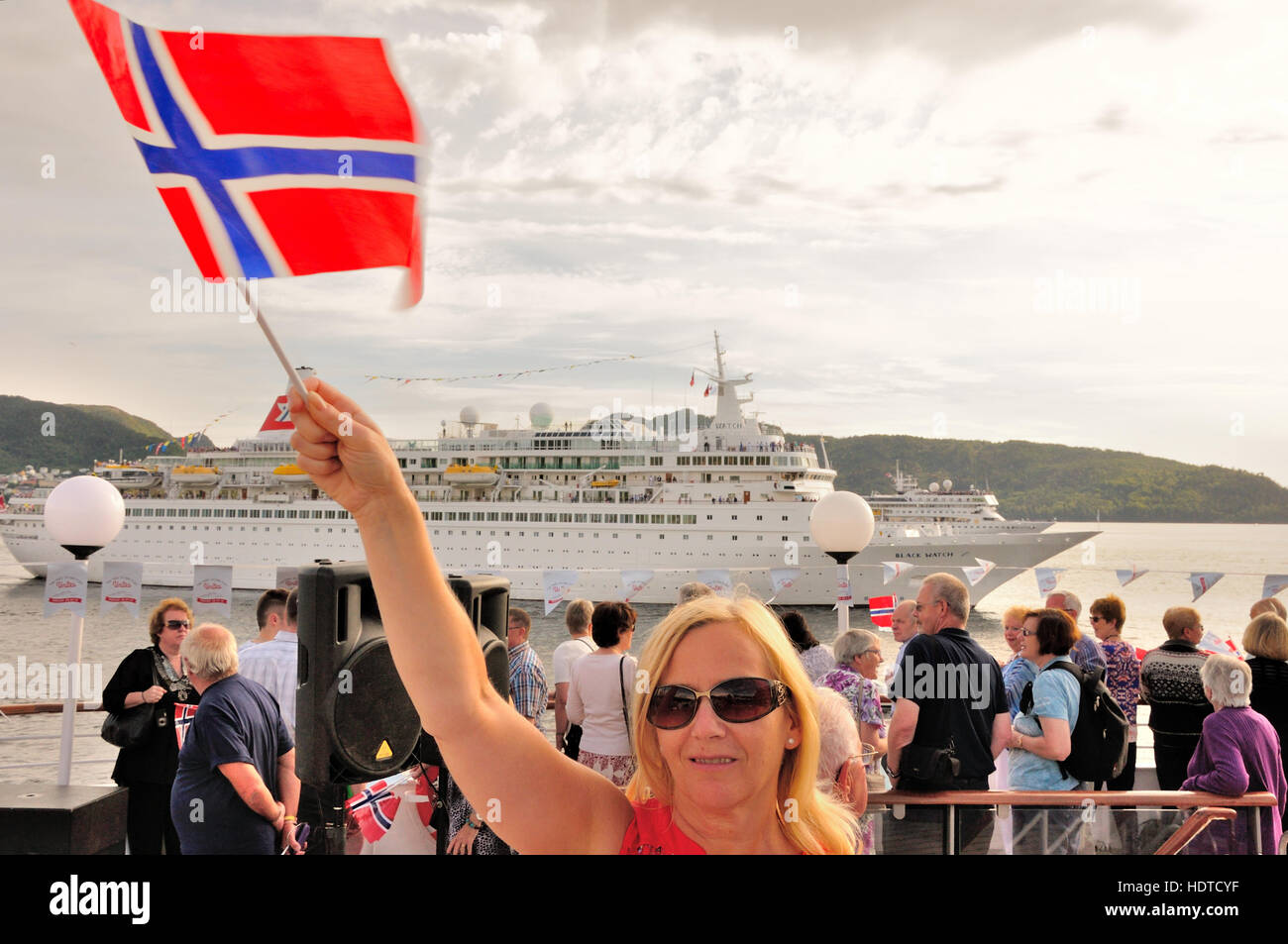 Ships leaving Bergen Harbour Norway. passenger waves goodbye with Norwegian flag,passengers looking at ships Stock Photo