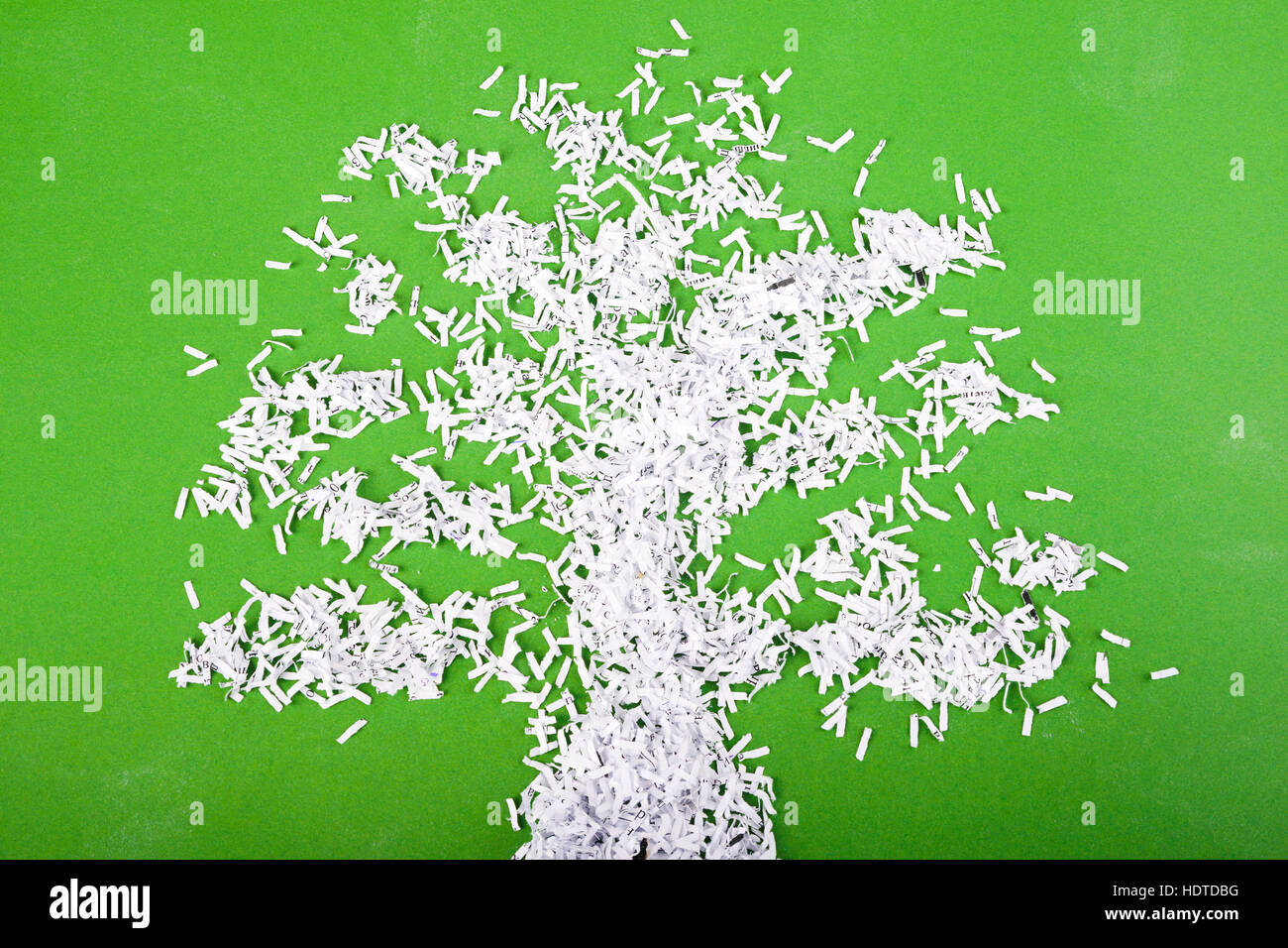 simple green tree symbol made from shredded paper particles on green background Stock Photo