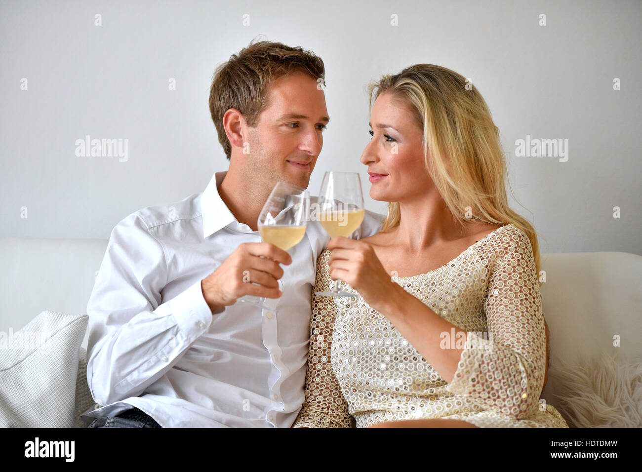 Man, woman, couple on sofa, in love, wine, glass abut Stock Photo