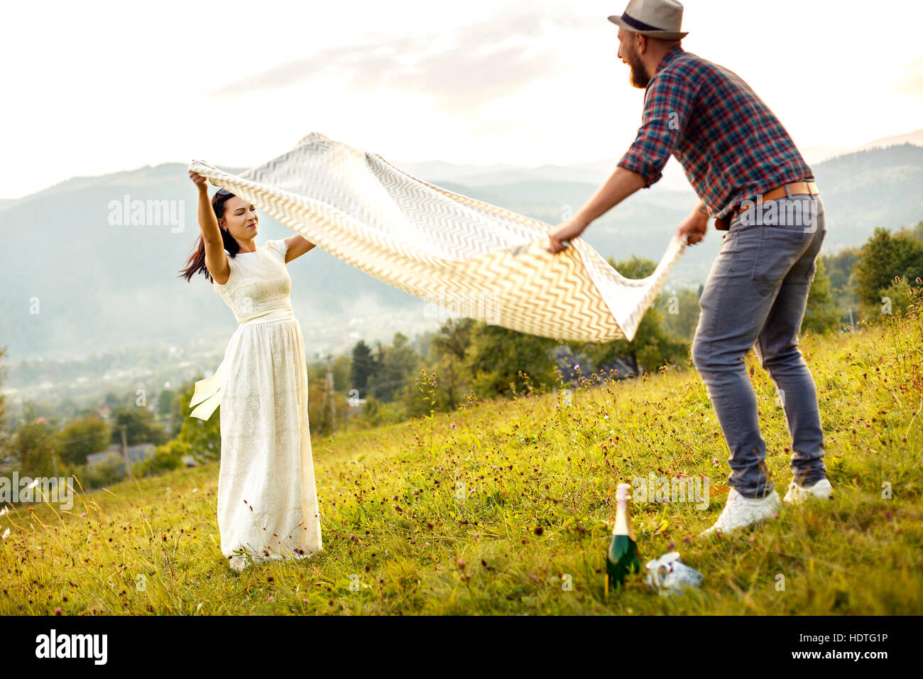 couple in love preparing for picnic. spread white plaid. Stock Photo