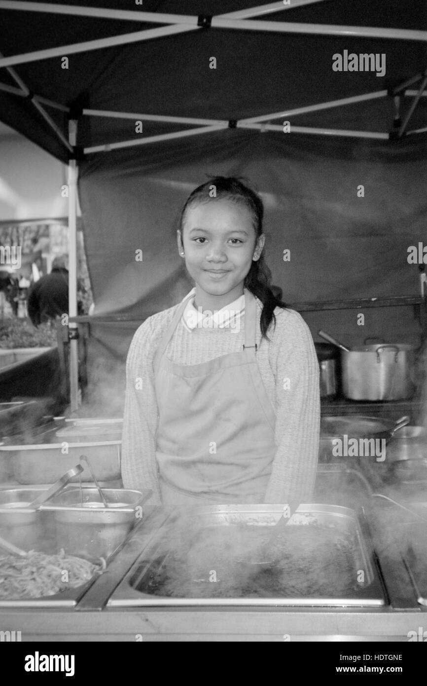 young pretty thai woman serving street food at a market stall in palmerston road southsea england uk Stock Photo