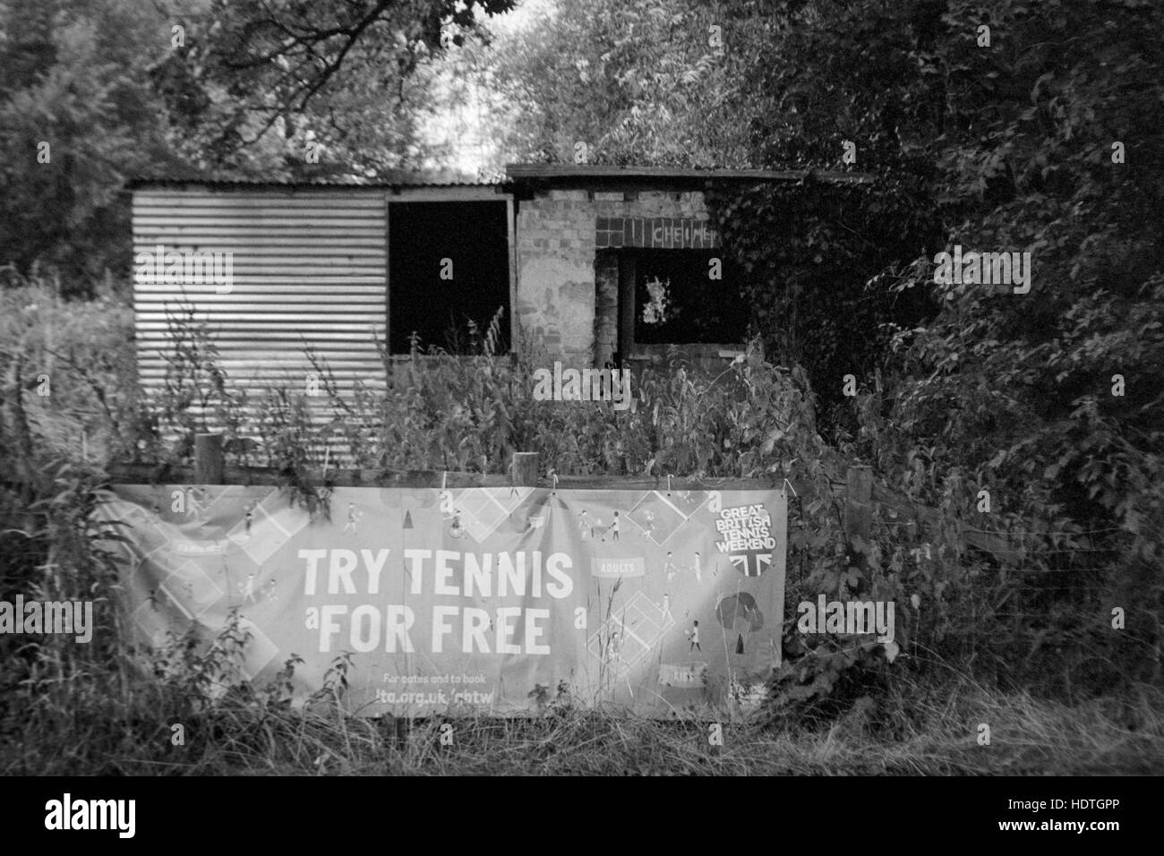 a tumbledown shack with a try tennis for free banner in front england uk Stock Photo