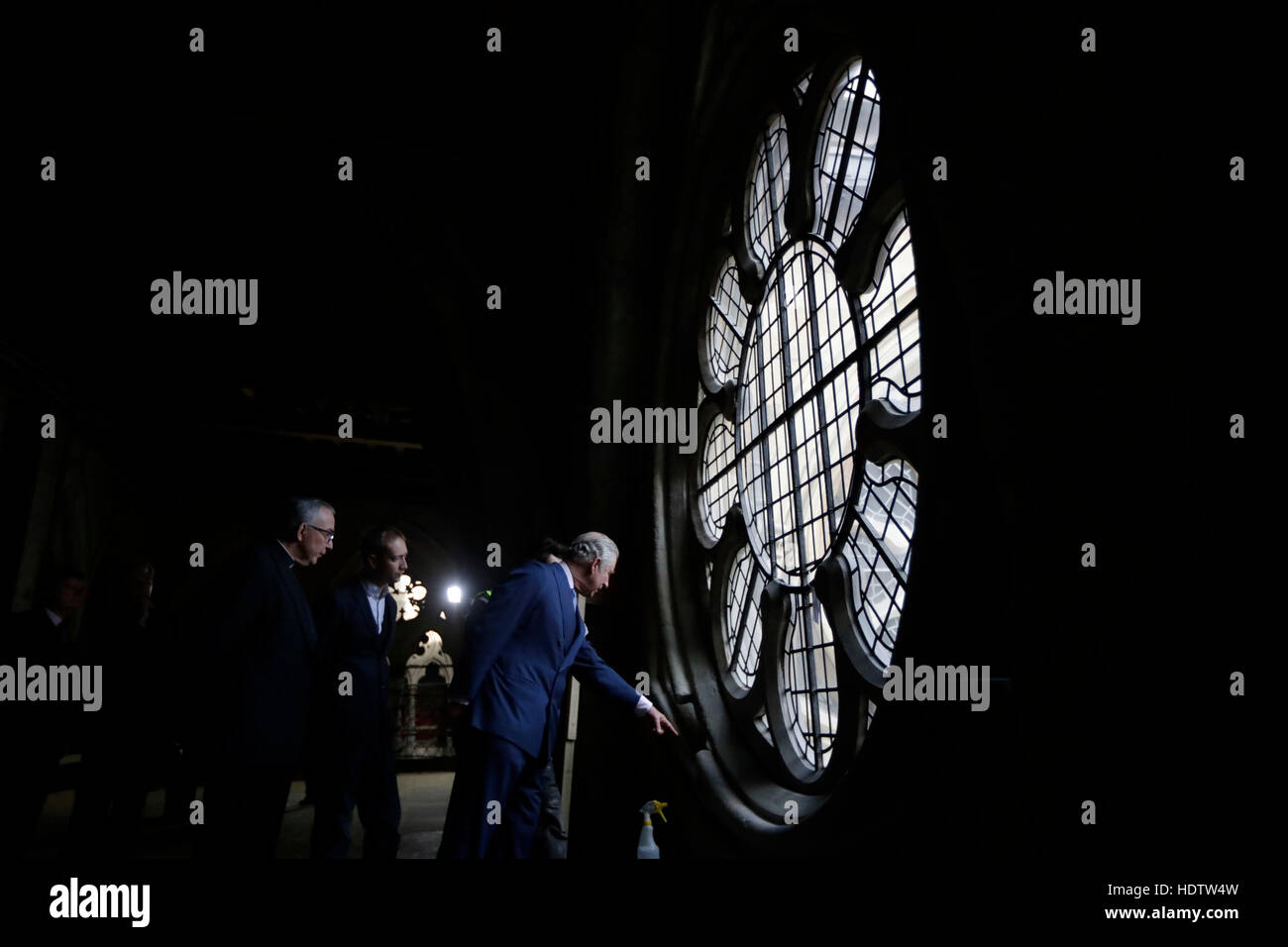 The Prince of Wales points as he looks at works taking place beside a window, flanked by the Dean of Westminster John Hall (left) during his visit to the The Queen's Diamond Jubilee Galleries at Westminster Abbey in London. Stock Photo