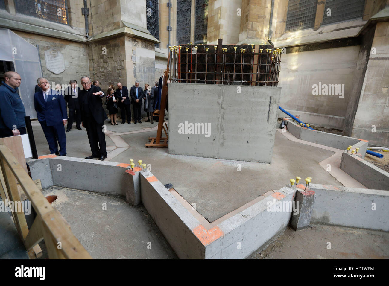 The Prince of Wales (second left) is shown the area around a foundation stone, on which he unveiled a plaque, for a new stair and lift tower by the Dean of Westminster John Hall (third left) during his visit to the The Queen's Diamond Jubilee Galleries at Westminster Abbey in London. Stock Photo