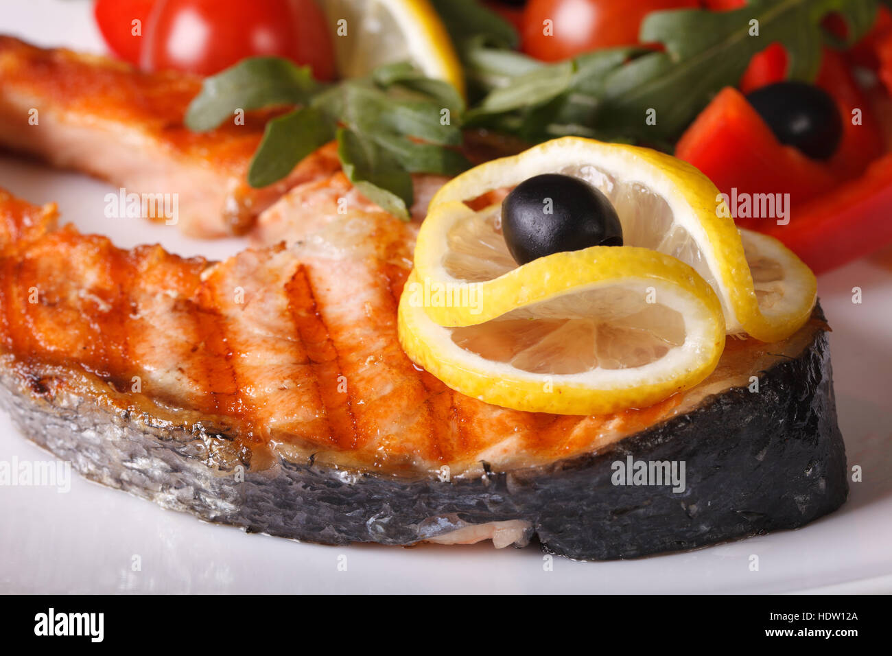 Grilled salmon steak with lemon on a plate macro horizontal Stock Photo ...