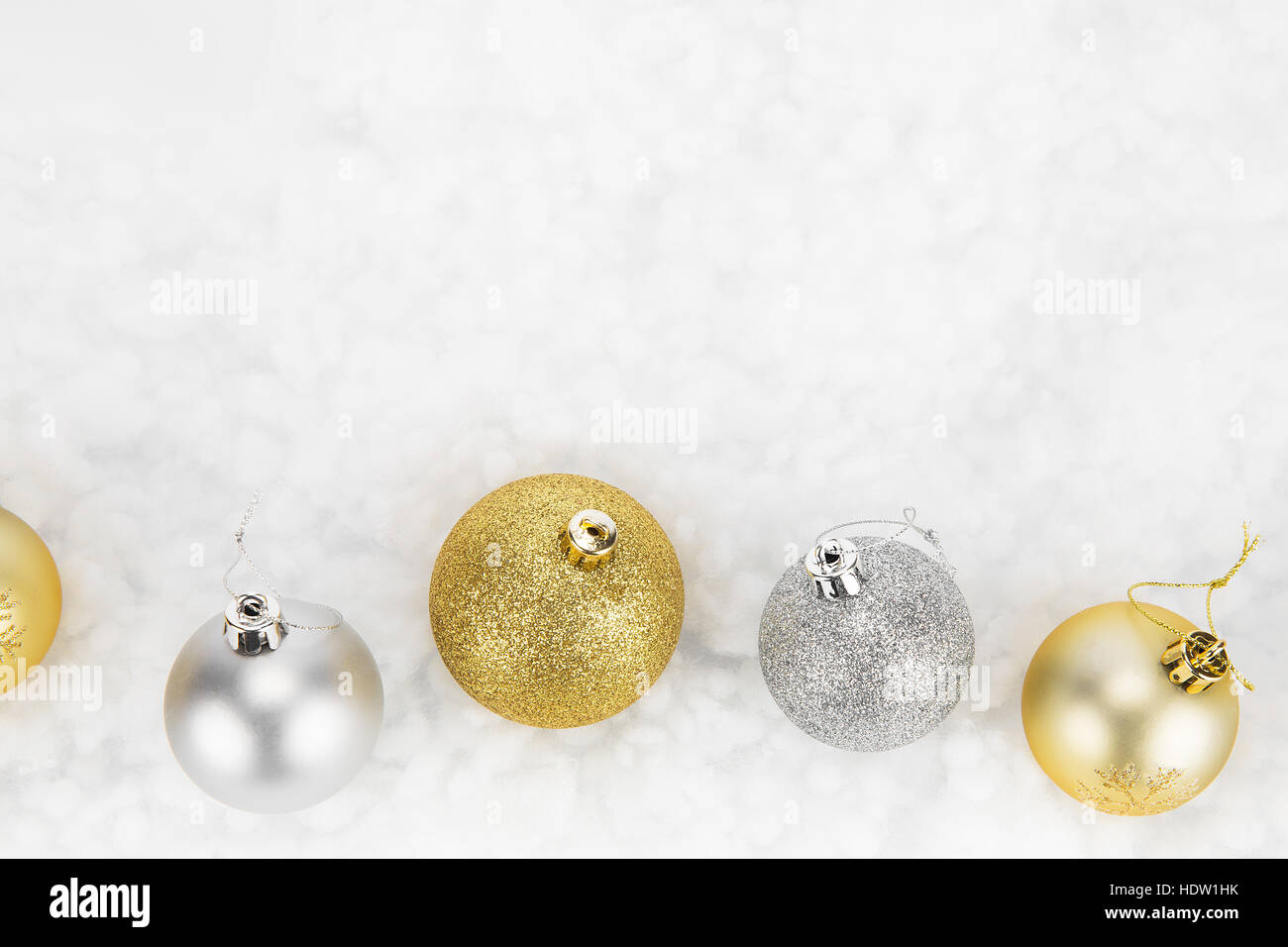 Gold and silver Christmas baubles isolated against white on abstract background Stock Photo